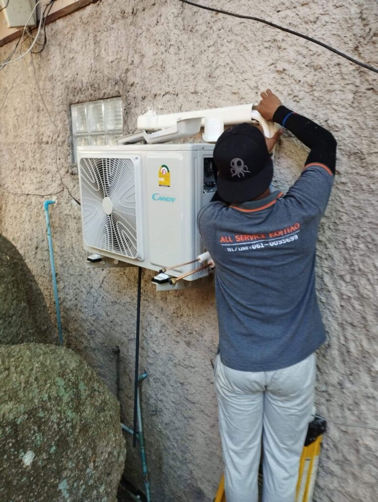All Service Koh Tao technician installing and servicing an outdoor air conditioning unit in Koh Tao, Thailand