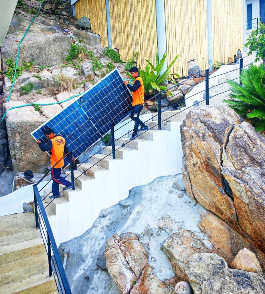 All Service Koh Tao technicians installing a solar panel on a hillside property in Koh Tao, Thailand